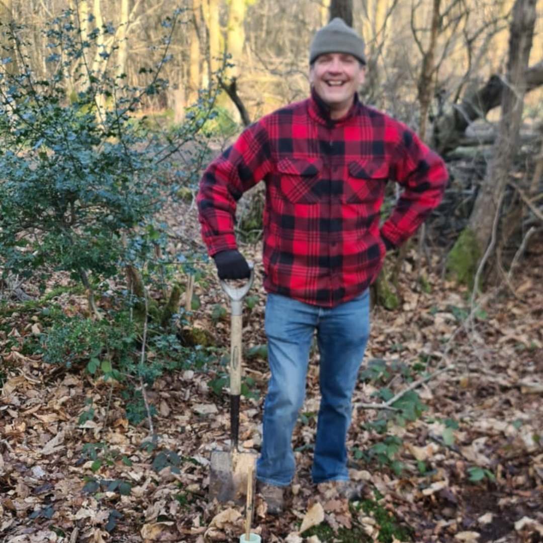 Man in the woods feeling proud of his woodland work